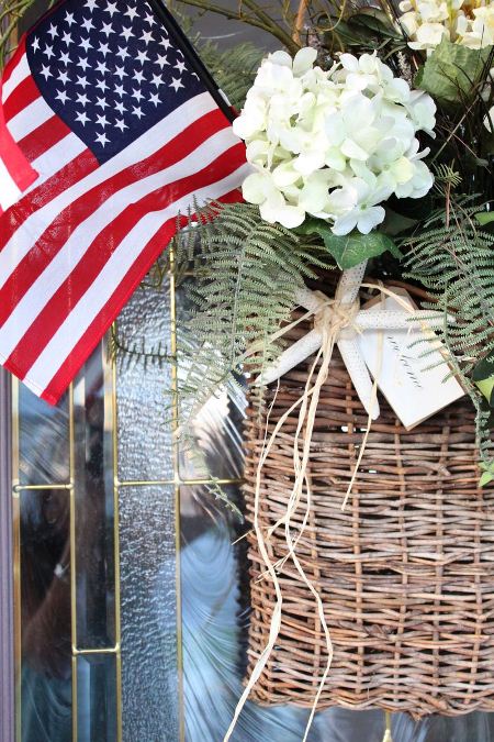 American flag in a basket of flowers, ivy, and ferns.