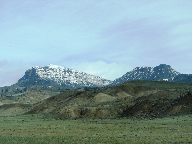 Snow-capped peaks of the Absaroka Range are the backdrop for rolling hills in Wapiti Valley.